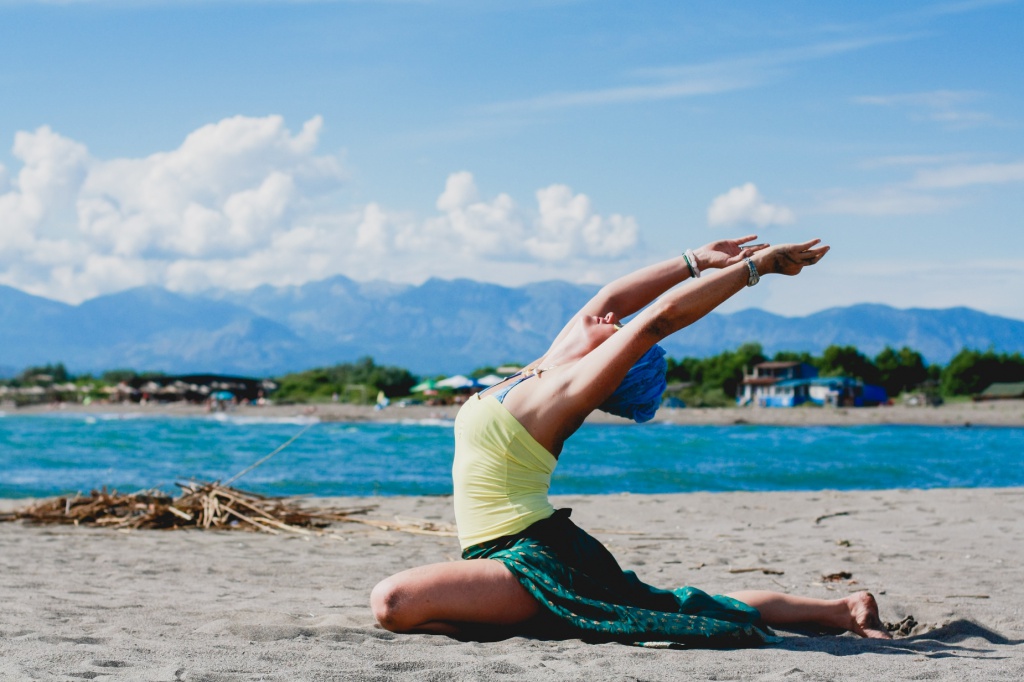 Йога на берегу. Йога на море. Женская йога. Женщина занимается йогой на море. Йога женская практика.
